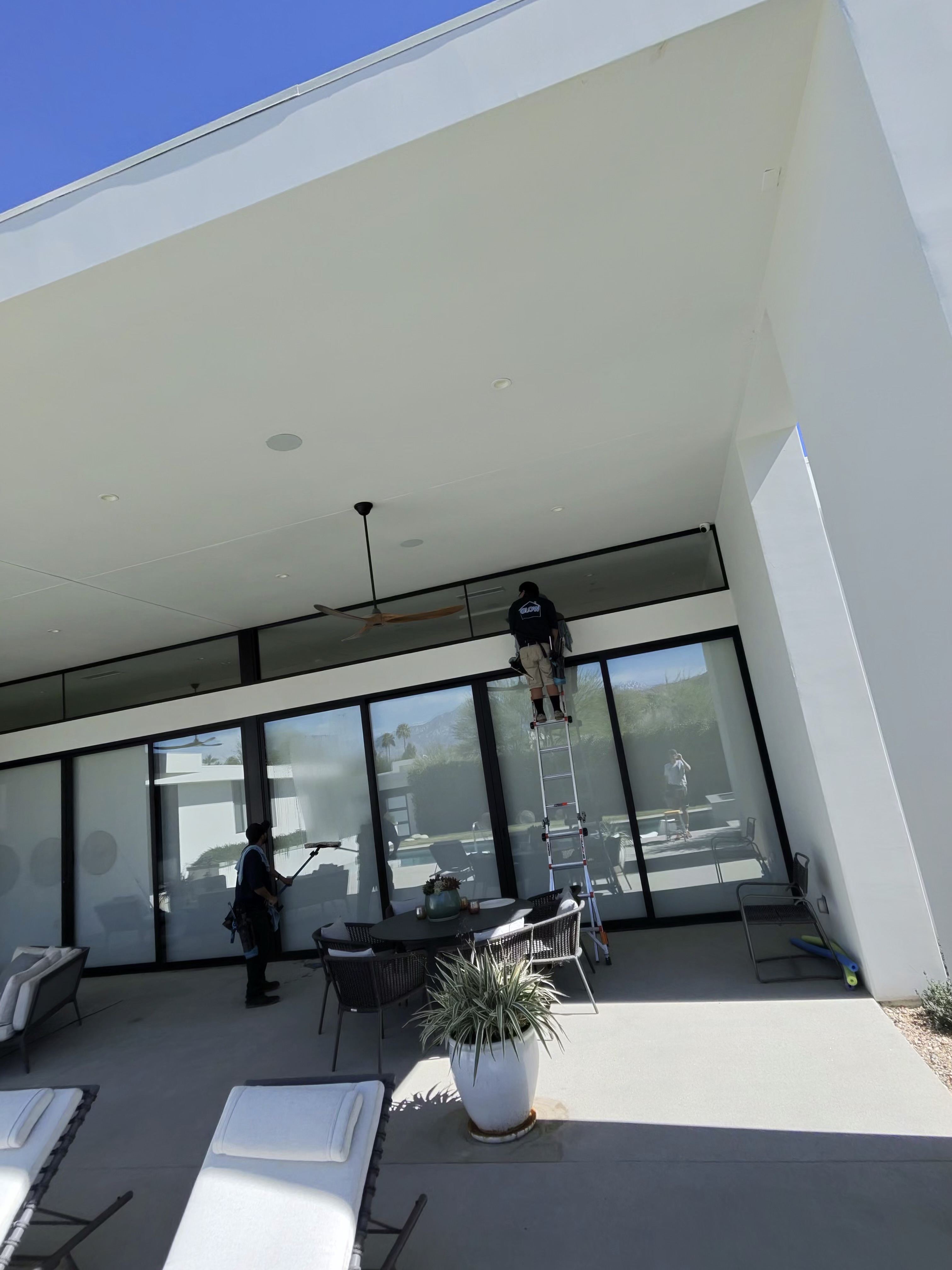 Team cleaning exterior of modern home